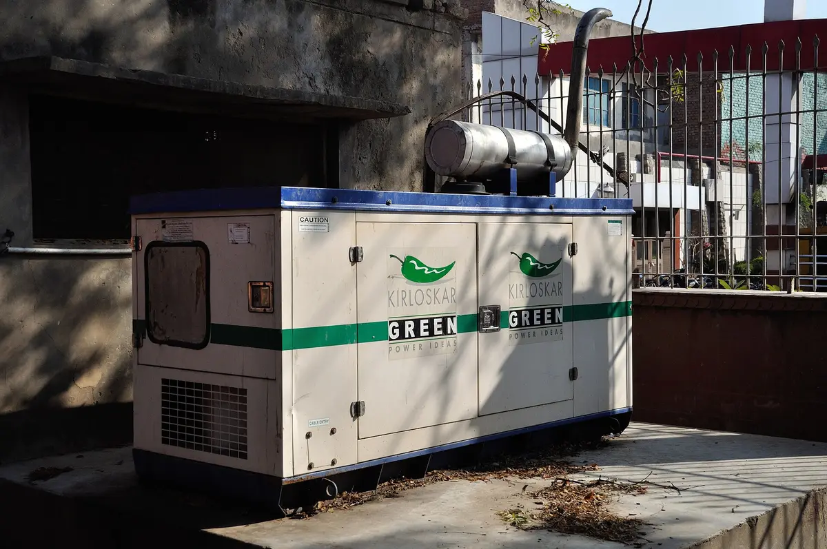 Grupo electrógeno diésel cabinado, instalado a la intemperie junto a un edificio